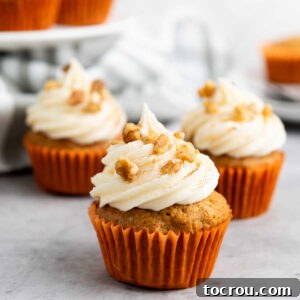 Rustic Carrot Cake Cupcakes 12 Carrot cake cupcakes in orange paper liners and topped with piped frosting and chopped walnuts.