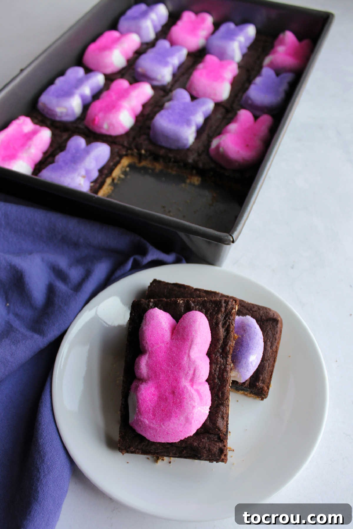 Delicious layers of Peeps S'mores Bars. Peep smore bars with pink and purple bunny peeps, a gooey chocolate layer and graham cracker base.