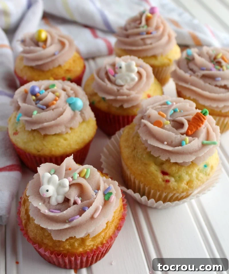 Festive Cupcakes with Edible Cookie Dough Frosting sugar cookie dough frosting swirls on cupcakes with cute bunny and carrot sprinkles.