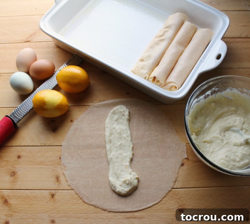 crepe being filled with lemon ricotta filling with zested lemon and eggs nearby.