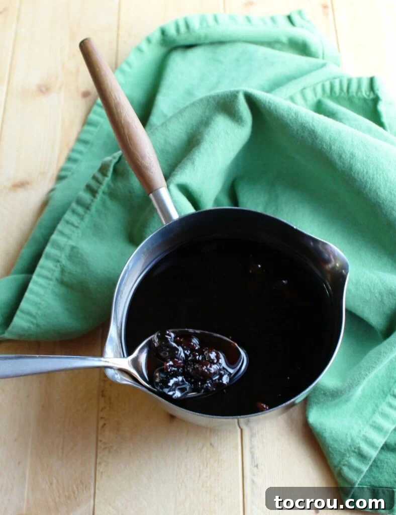 cherry syrup in saucepan ready to be spooned over crepes.