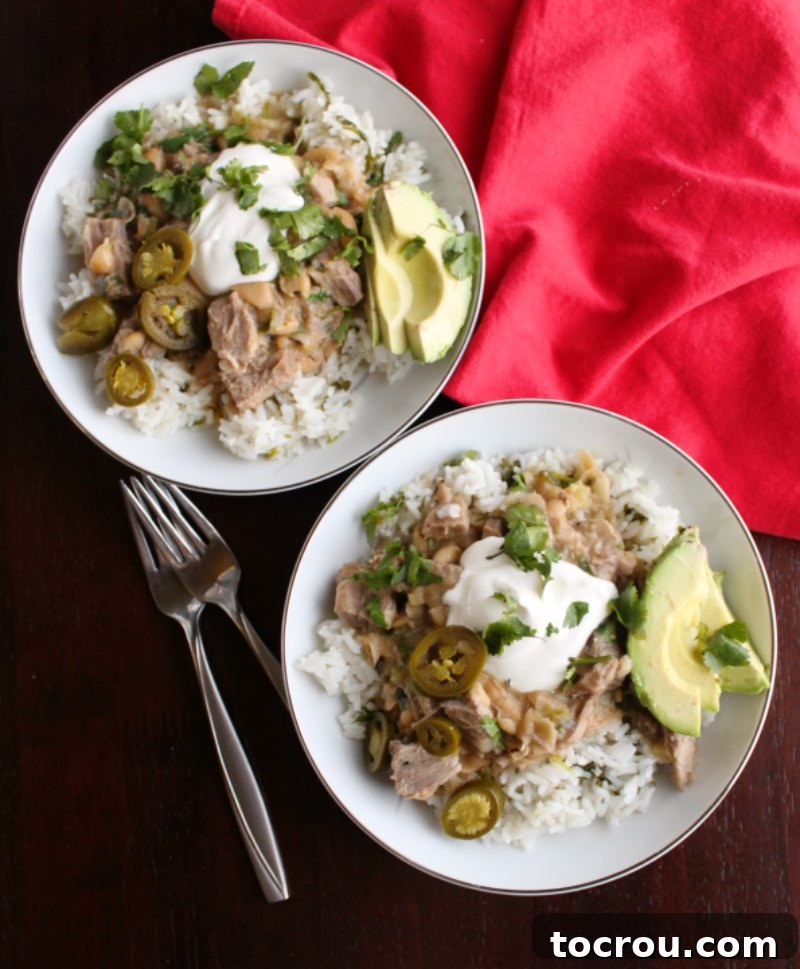 Zesty Instant Pot Salsa Verde Pork 4 Beautifully plated salsa verde pork burrito bowls adorned with fresh sour cream, zesty jalapenos, aromatic cilantro, and perfectly fanned avocado slices.