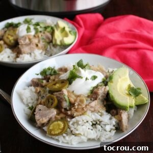 Zesty Instant Pot Salsa Verde Pork 6 Two rice bowls topped with salsa verde pork topped with sour cream with cilantro and avocado.
