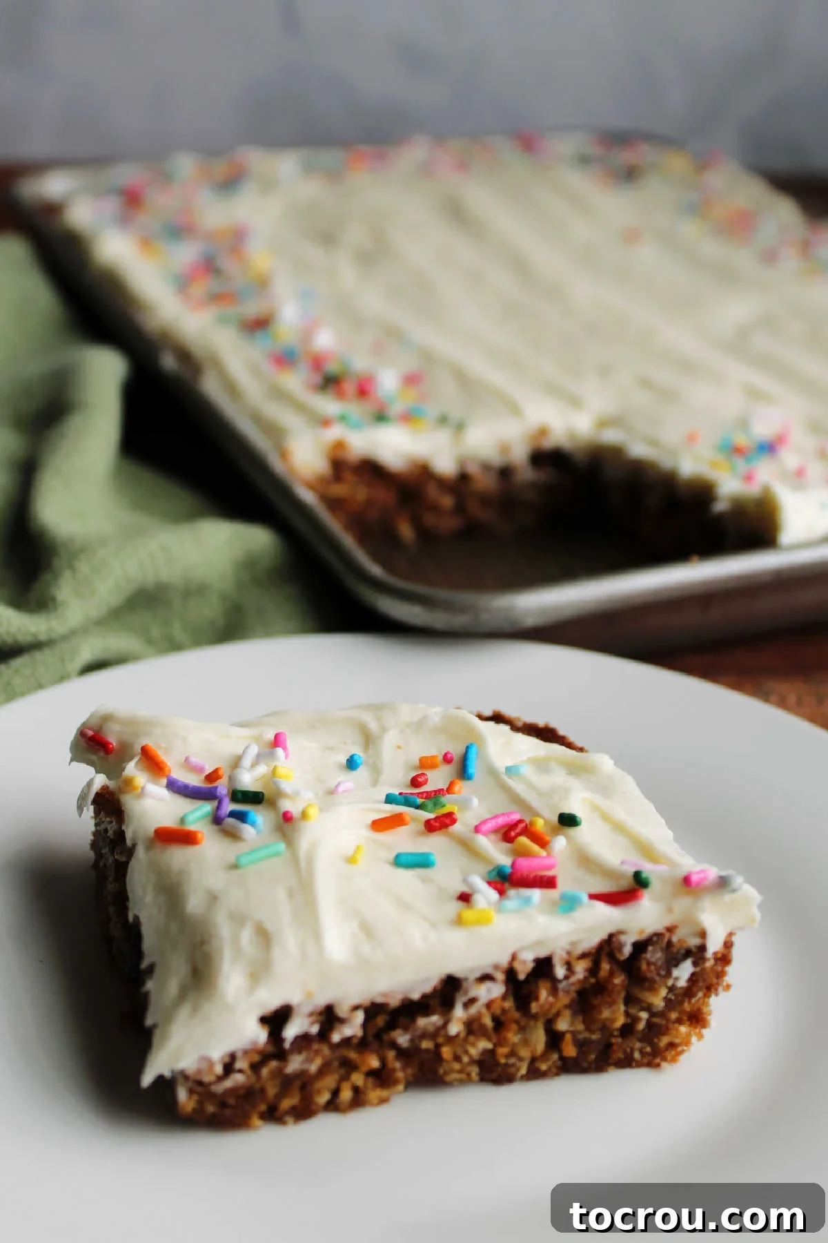 Square of homemade oatmeal creme pie bars with marshmallow fluff buttercream on small dessert plate, ready to be eaten.