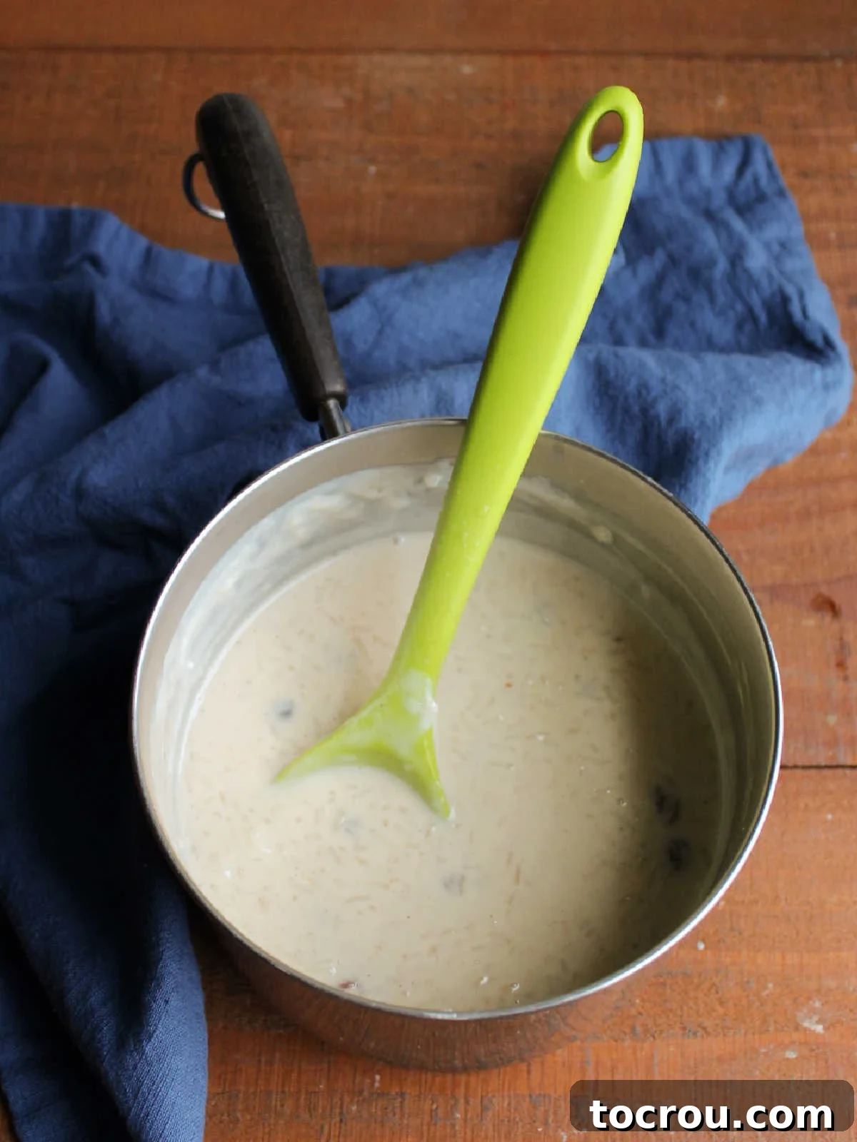 Cooked condensed milk rice pudding in a saucepan, having reduced to the level of the rice, indicating it's ready to be removed from the heat and cool.