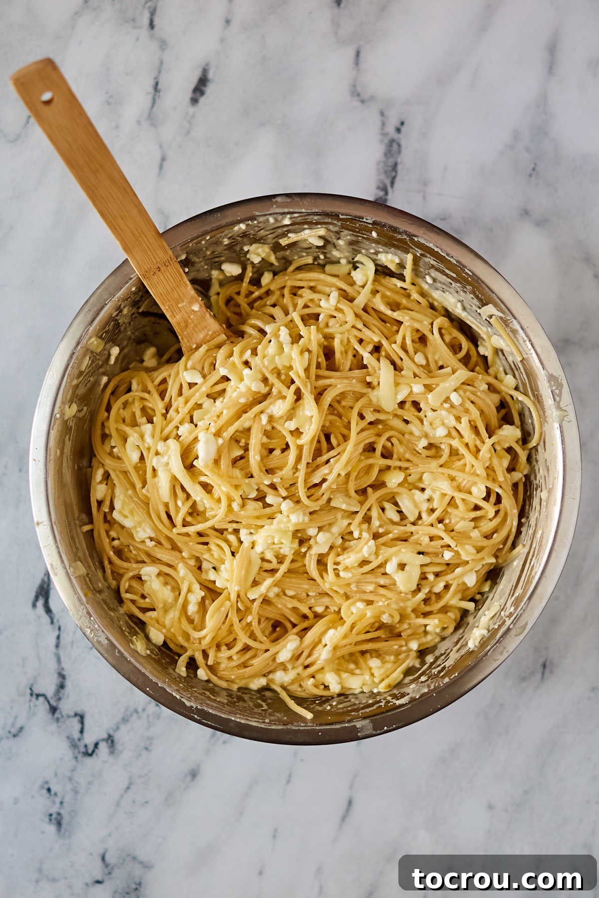 Bowl of spaghetti noodles coated in egg and cheese mixture.