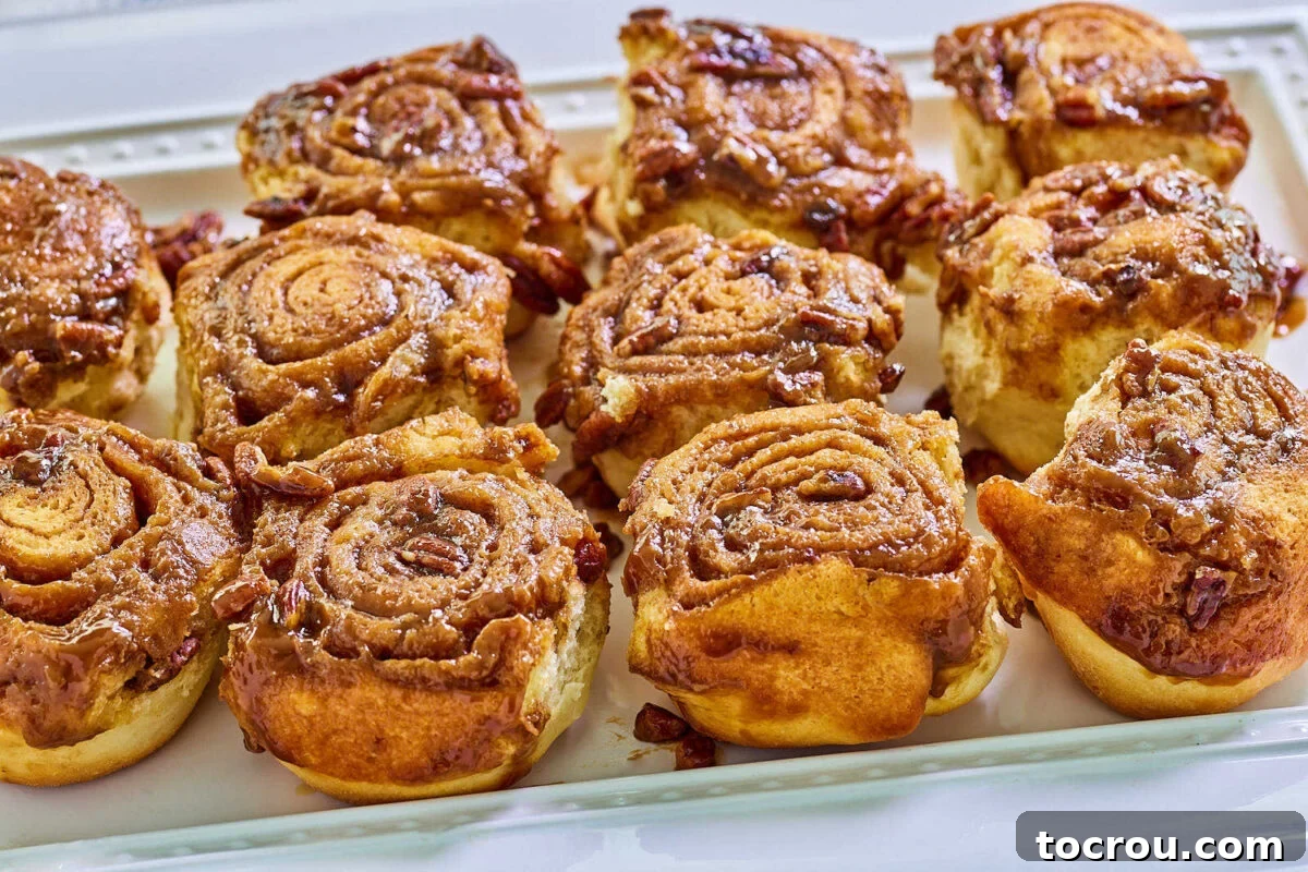 Platter of cinnamon buns with sticky caramel and pecan topping, ready to eat. 
