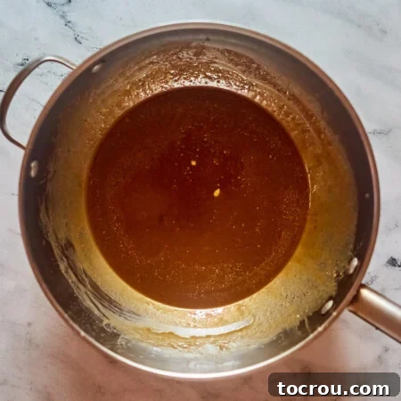Saucepan with boiled milk, butter and brown sugar caramel mixture inside.