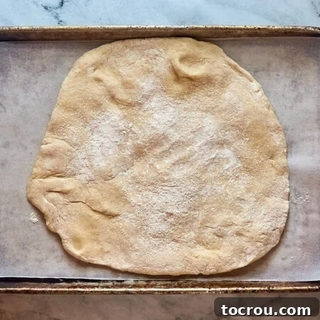 Pressing out proofed cinnamon roll dough, getting ready to add cinnamon sugar filling.