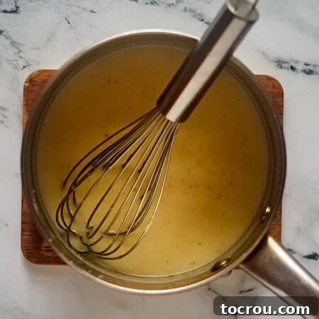 Saucepan with boiled milk, butter, cornmeal, water, and salt inside.