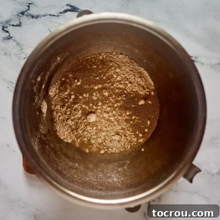 Flour and yeast in mixer bowl, ready to make cinnamon roll dough.