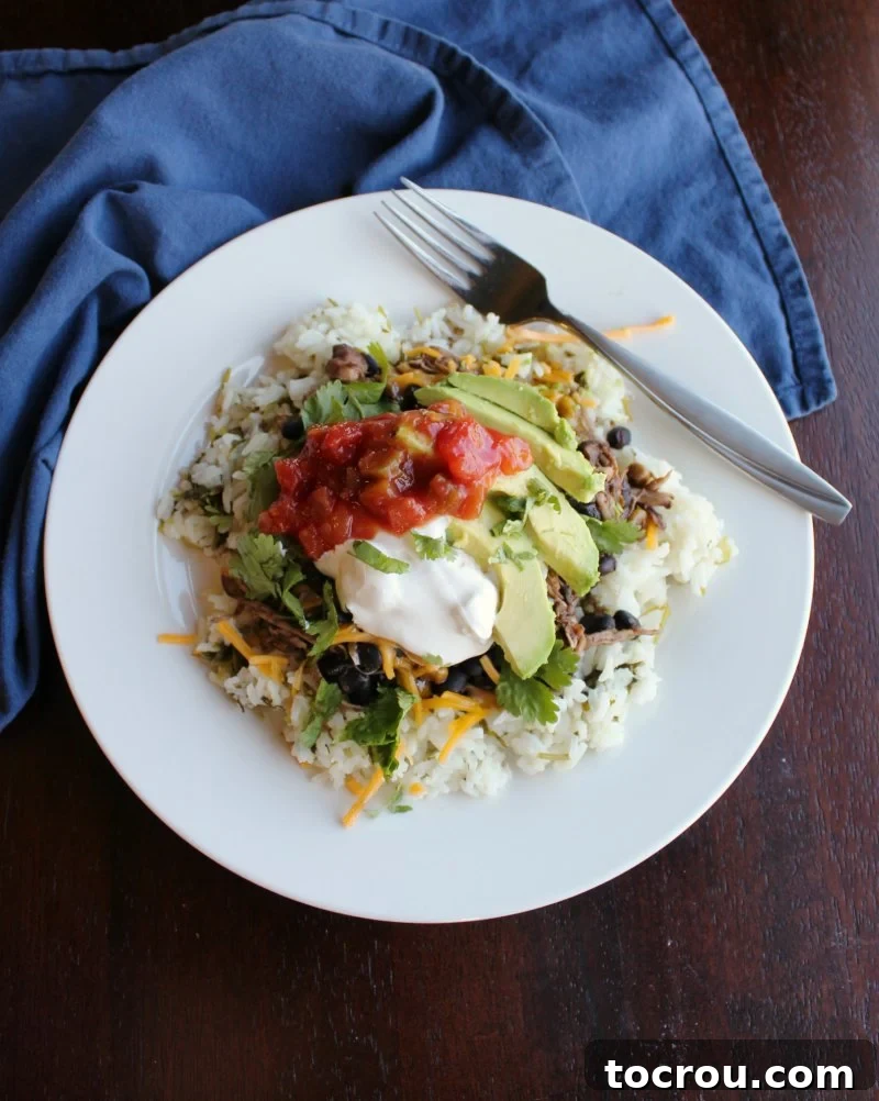 bowl of cilantro lime rice topped with salsa chicken and toppings.