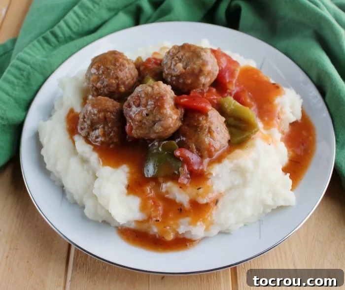 Enjoy the flavors of Swiss steak, but made even simpler. Swiss steak style meatballs are ready in no time in the instant pot. plate full of mashed potatoes and swiss steak style meatballs with tomato gravy.