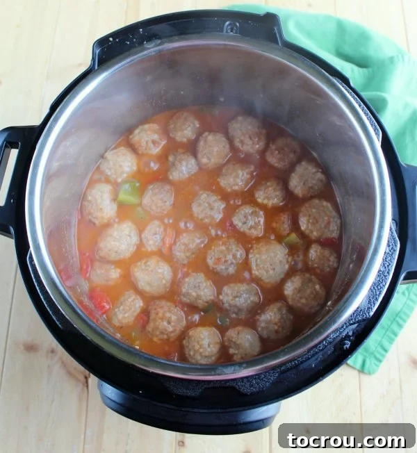Instant Pot Swiss Steak Inspired Meatballs 4 steamy hot swiss steak meatballs in instant pot.