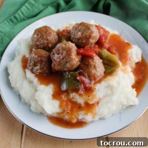 Instant Pot Swiss Steak Inspired Meatballs 6 plate full of mashed potatoes and swiss steak style meatballs with tomato gravy.
