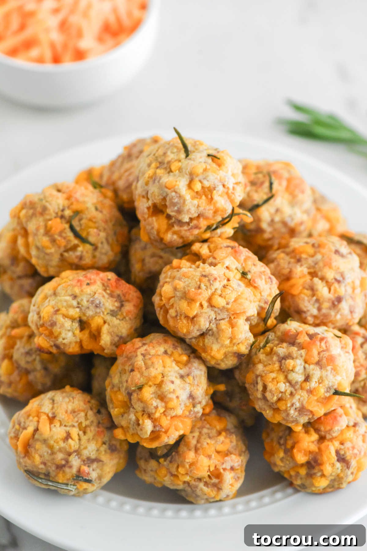 Sausage Cheese Bites 10 Pile of cheesy bisquick sausage balls on a plate, ready to eat.
