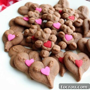 Plate of chocolate spritz hearts and bears with pink and red heart decorations on them