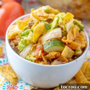 Frito Taco Salad Close-up of a bowl of Frito salad showing crisp lettuce, cucumbers, cheese, seasoned taco meat, and Fritos, all perfectly tossed in homemade Catalina dressing.