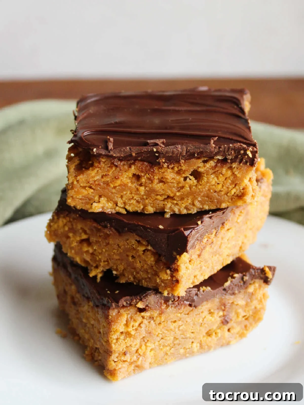 An irresistible stack of homemade treats. A stack of delicious peanut butter cornflake bars, showcasing their crunchy and chewy layers topped with smooth chocolate.