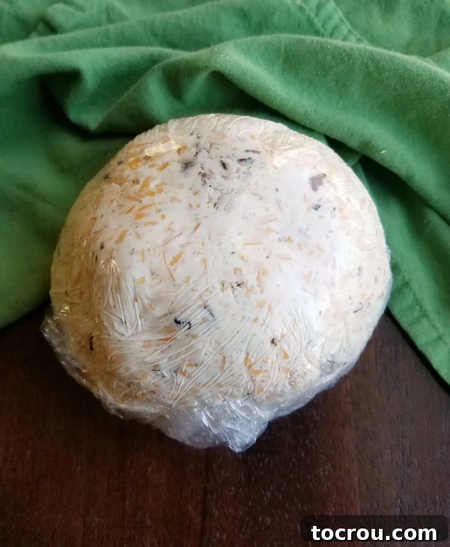 cheese ball wrapped in plastic wrap ready to chill.