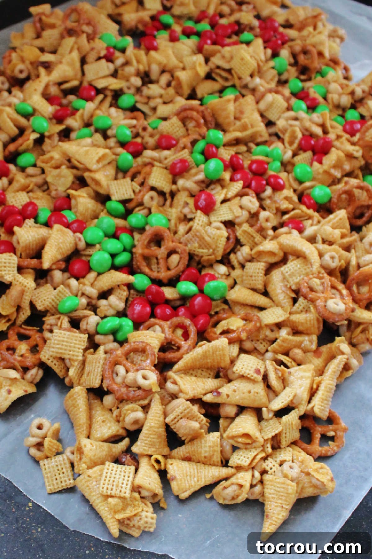 Caramel snack mix with bugles, pretzels and more coated in caramel mixture and cooked until crunchy cooling on wax paper.