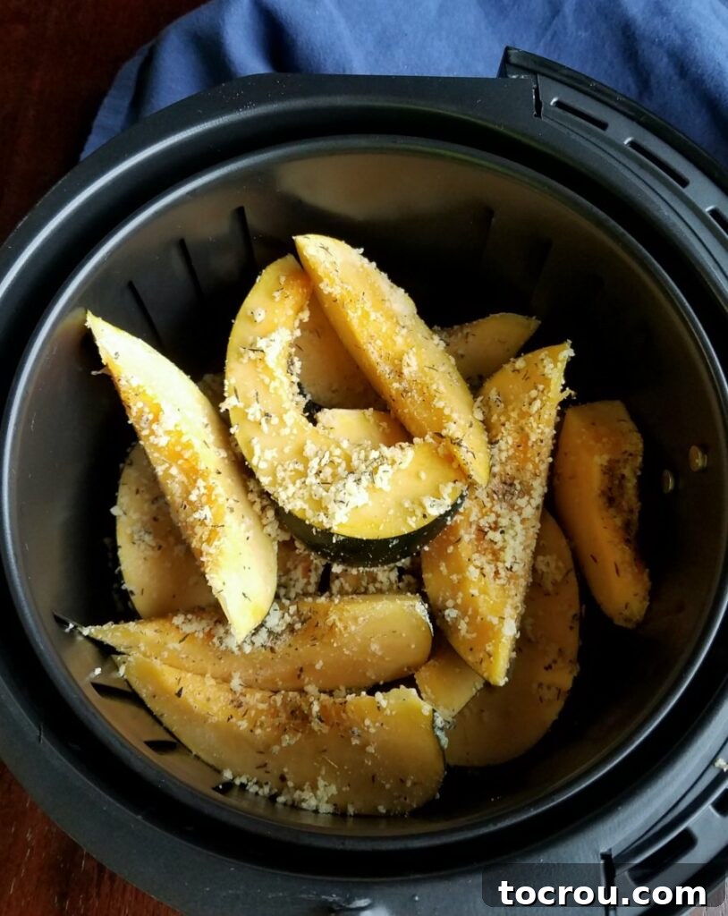 Crispy Parmesan Air-Fried Acorn Squash 4 slices of acorn squash in air fryer basket ready to cook.