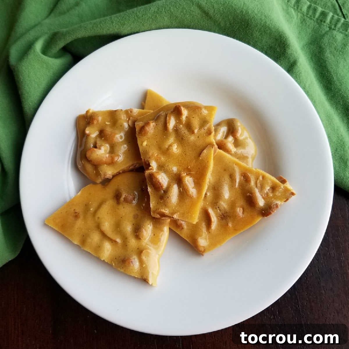 Plate of golden-brown, crunchy pieces of easy microwave peanut brittle.