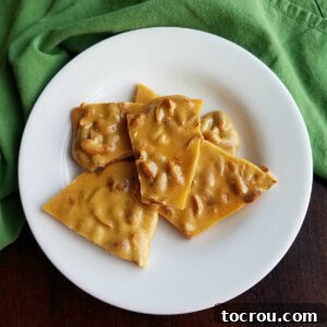 Plate of golden-brown pieces of easy microwave peanut brittle.