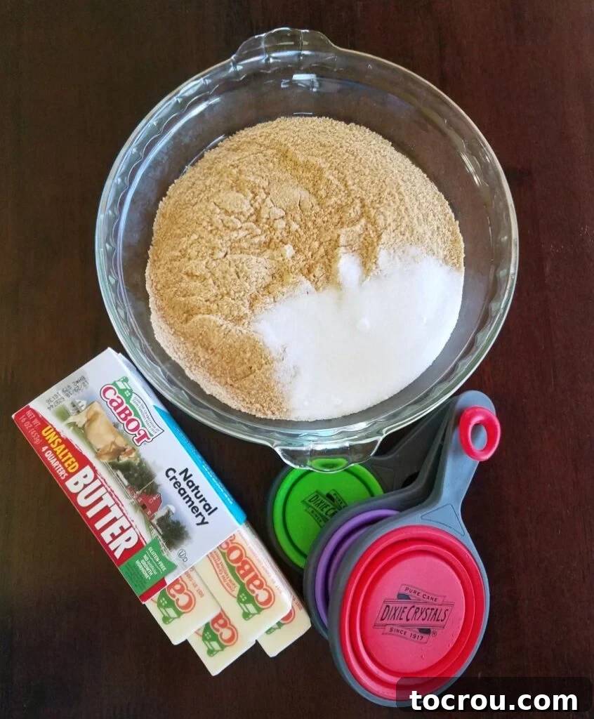 Ingredients for Graham Cracker Pie Crust Assortment of fresh ingredients for a graham cracker pie crust, including golden graham cracker crumbs, sugar, and butter, neatly arranged on a rustic wooden surface.
