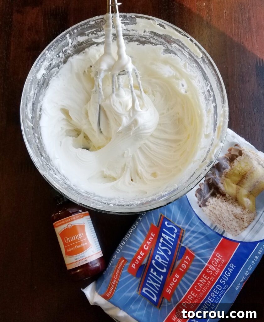 Creamy Orange Cheesecake Filling Prep Mixing bowl filled with creamy cheesecake center, powdered sugar, and orange emulsion, ready to be combined for the truffles.
