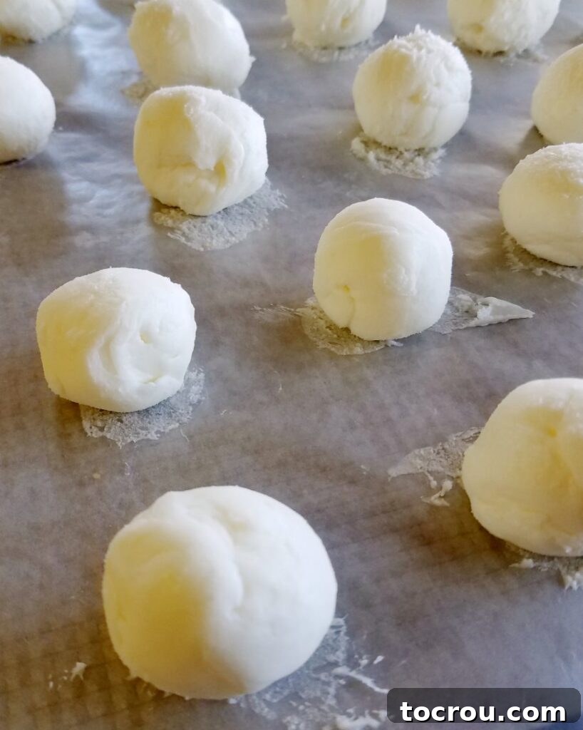 Frozen Cheesecake Truffle Centers Smooth, rounded balls of frozen cheesecake filling, prepared for their chocolate coating.