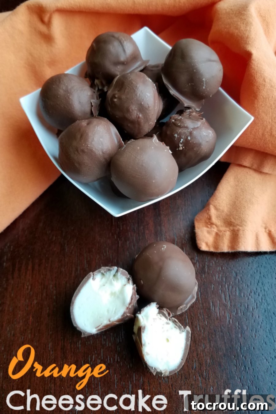 Decadent No-Bake Orange Cheesecake Bites Close-up of creamy orange cheesecake bites, coated in chocolate, showcasing their rich, no-bake goodness.