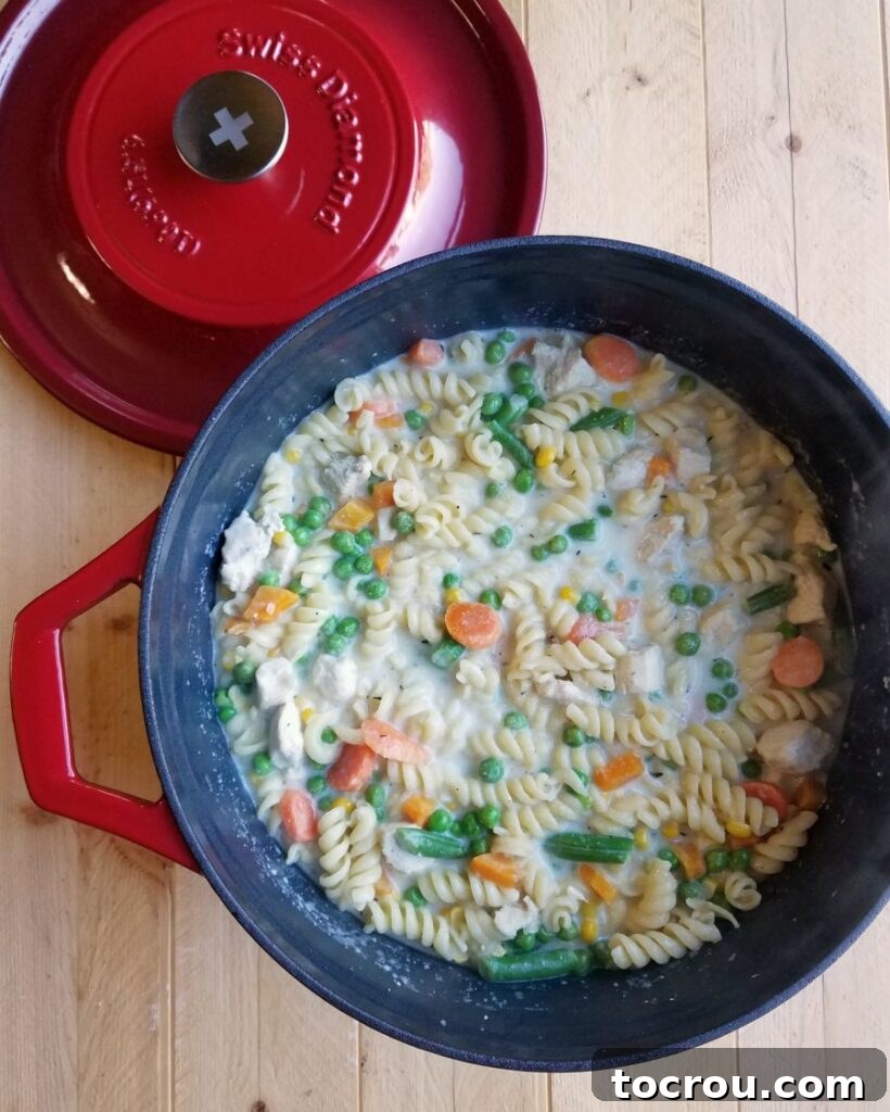 The creamy base of the One-Pot Chicken and Noodles in a Dutch Oven Creamy sauce simmering in a Dutch oven, forming the base for a one-pot pasta meal.