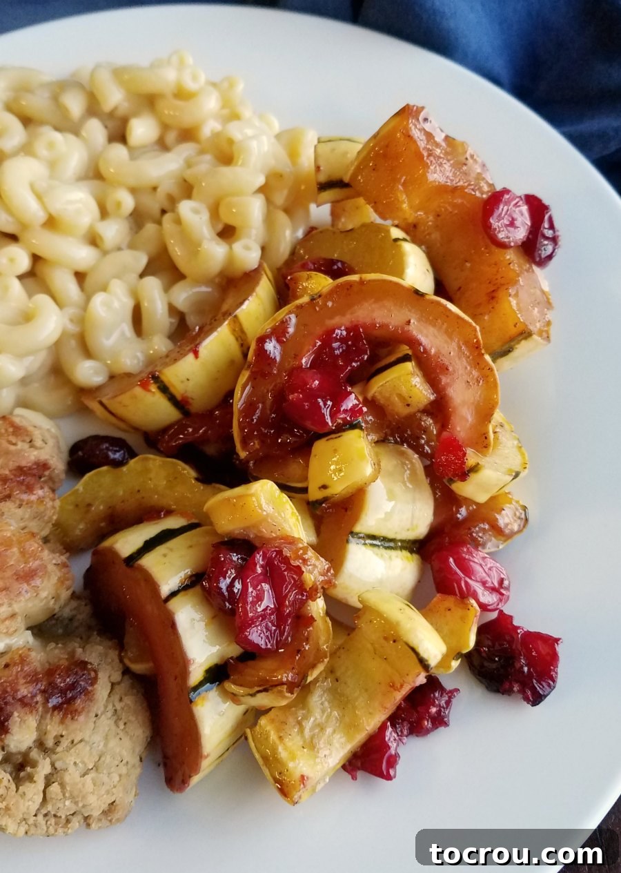 Dinner plate with macaroni and cheese, chicken, and roasted delicata squash with burst cranberries and a honey glaze.