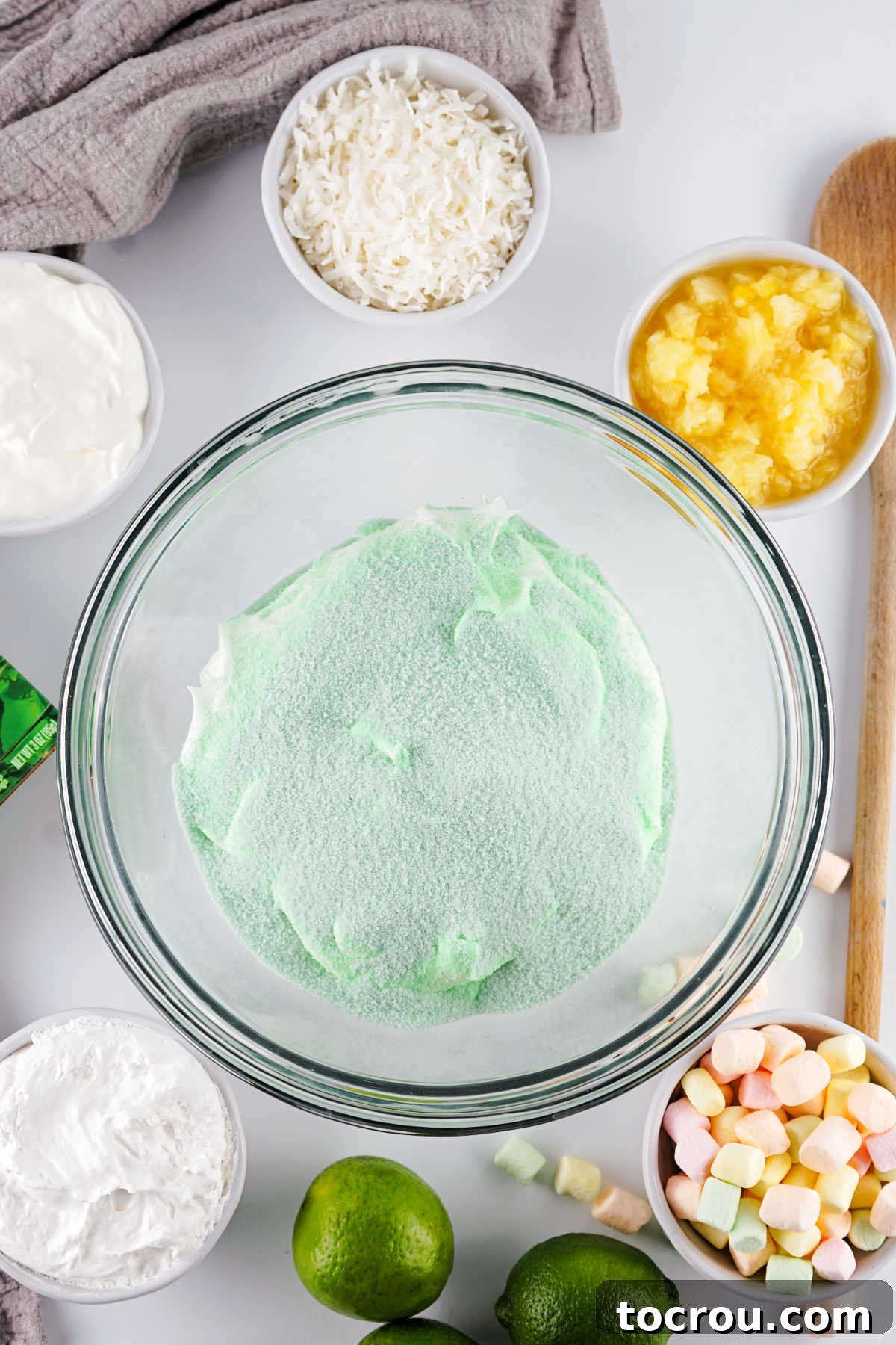 Cool Whip and lime jello powder in a large mixing bowl, ready to be combined.