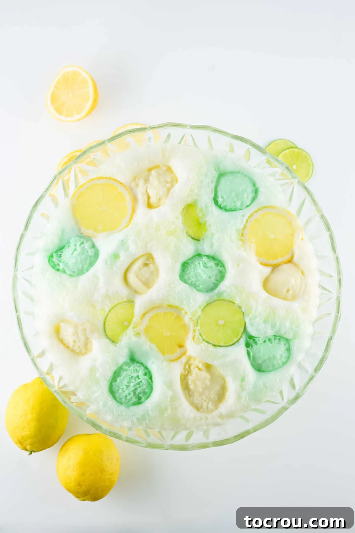 Looking down on scoops of lemon and lime sherbet floating on top of punch.