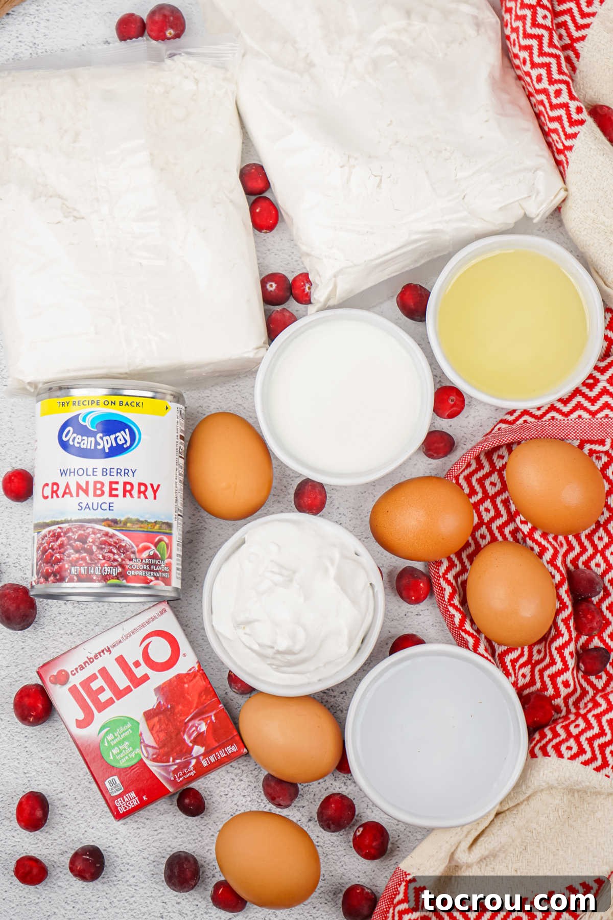 Ruby Cranberry Infusion Cake 3 Ingredients including cake mixes, eggs, oil, water, milk, cranberry jello, cranberry sauce, and cool whip, ready to be made into poke cake.