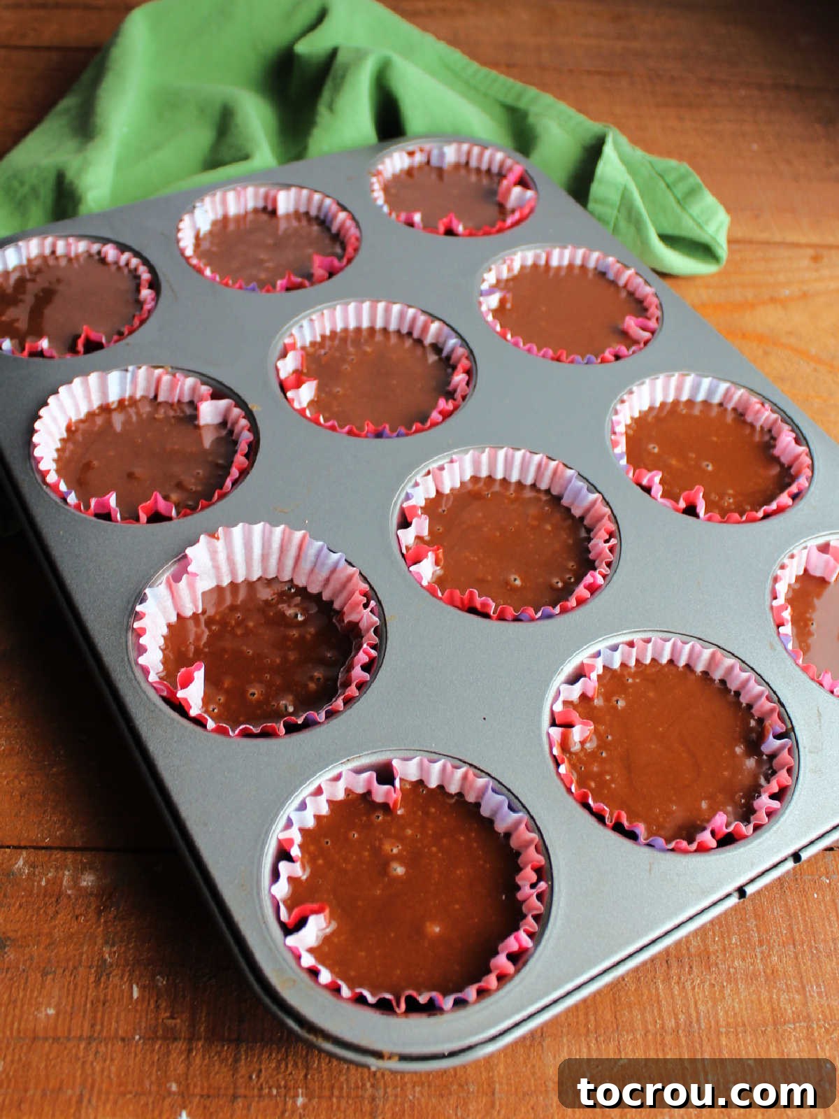 Crazy Delicious Chocolate Cupcakes 4 Chocolate cake batter scooped into paper liners in cupcake tin, ready to bake.