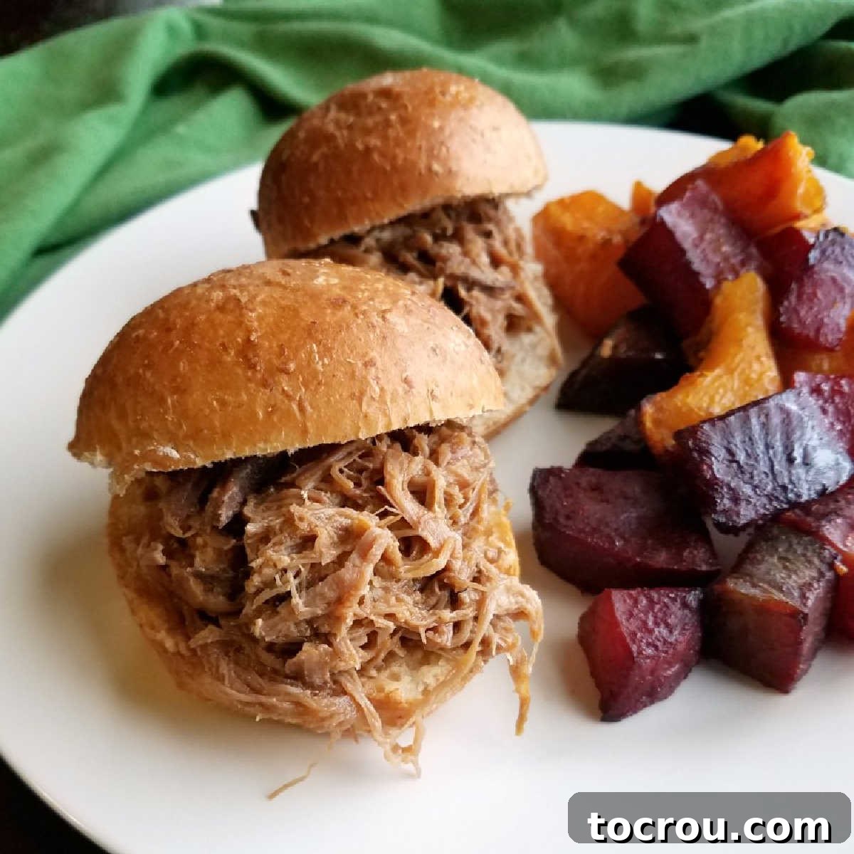 Hula Pork Sliders served on a plate with five-spice roasted vegetables, showcasing the tender, flavorful pulled pork.