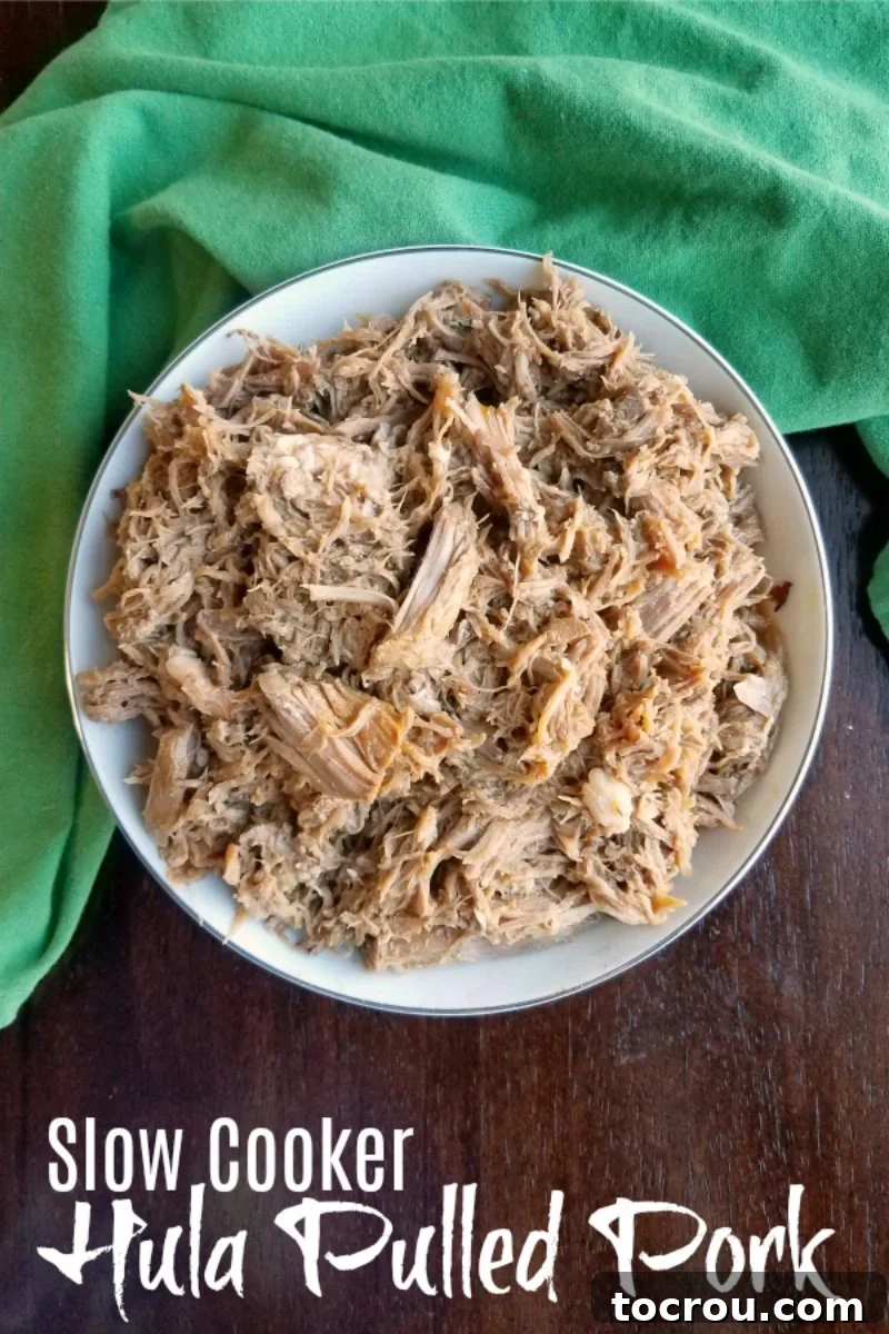 Bowl full of hula shredded pork with light sauce, perfectly cooked and ready to be served.