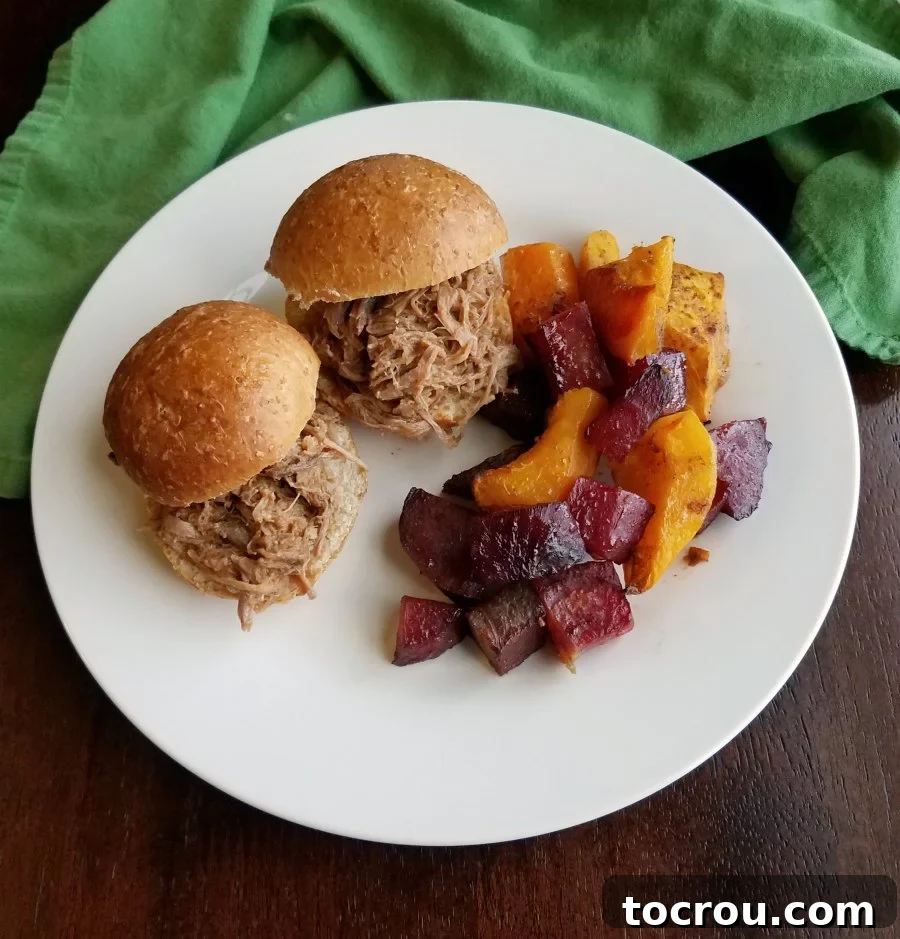 Dinner plate with delicious pulled pork sandwiches and a side of roasted beets and squash.