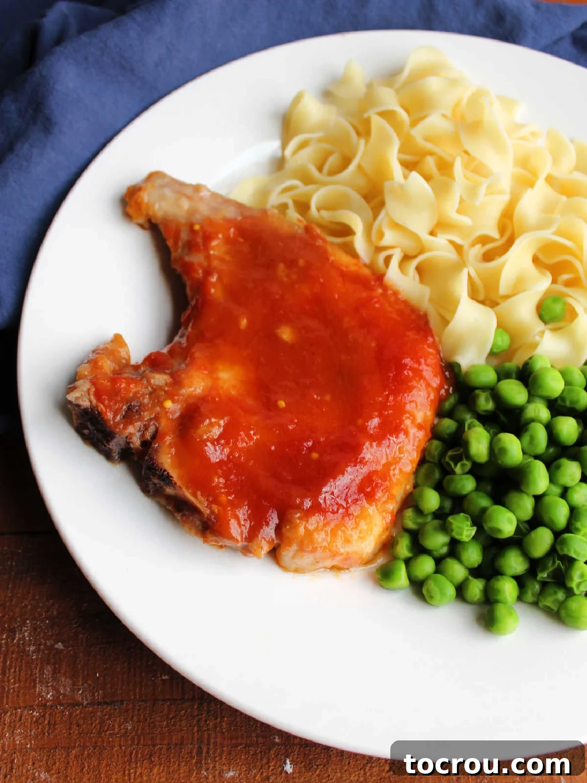 Close up of a tender pork chop after it has simmered in a simple sweet and sour sauce, ready to eat. 