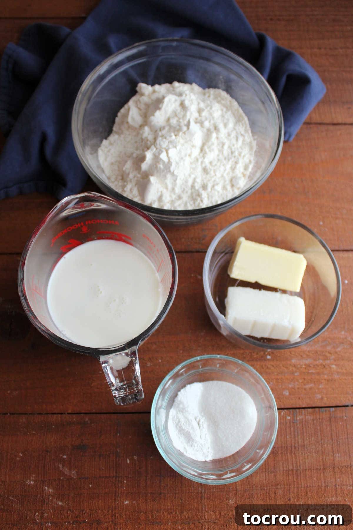 Ingredients including flour, sugar, salt, baking powder, milk, butter, and lard ready to be made into skillet biscuit bread.