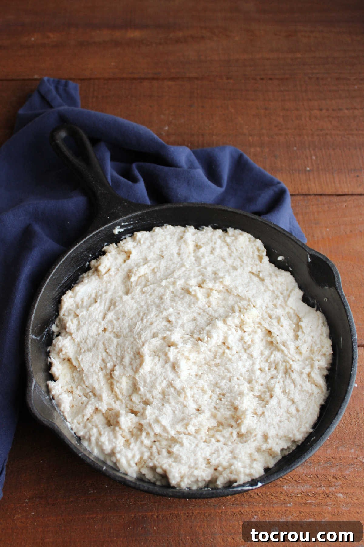 Sticky pone bread dough in cast iron skillet, ready to go in the oven.