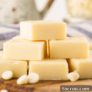 Cubes of creamy ivory vanilla fudge stacked on top of each other, showcasing their incredibly smooth and enticing texture.