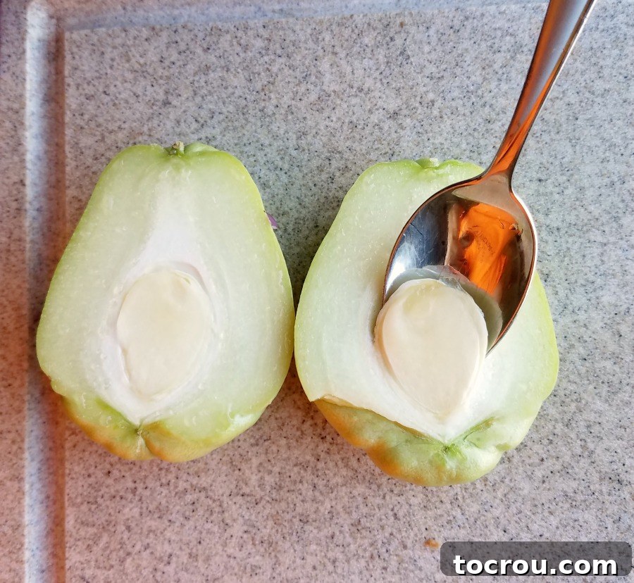 Sheet Pan Fiesta Breakfast 3 Scooping seed out of the middle of a chayote squash with a spoon.