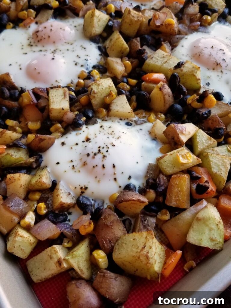 Sheet Pan Fiesta Breakfast 7 Close up of corner of pan showing roasted veggies and cooked eggs.