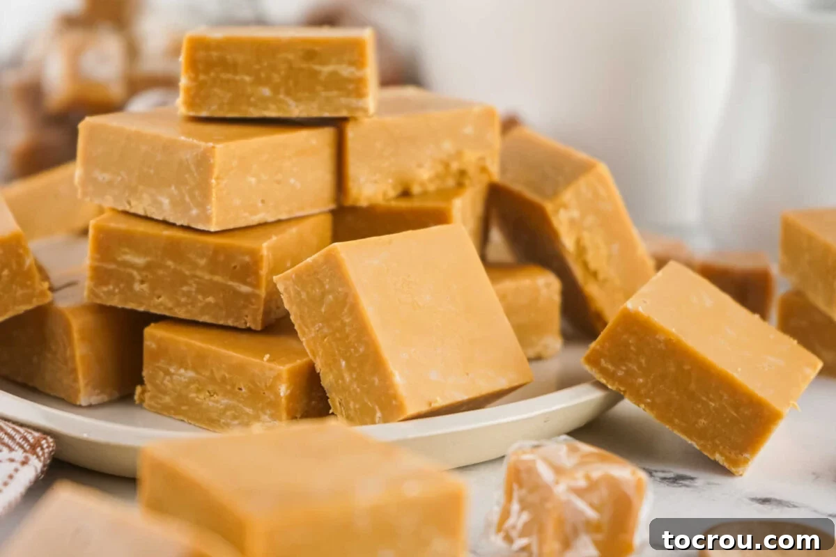 Delicious 2-Ingredient Caramel Fudge Squares Platter of caramel fudge squares next to wrapped caramel candies showing similarity in color.