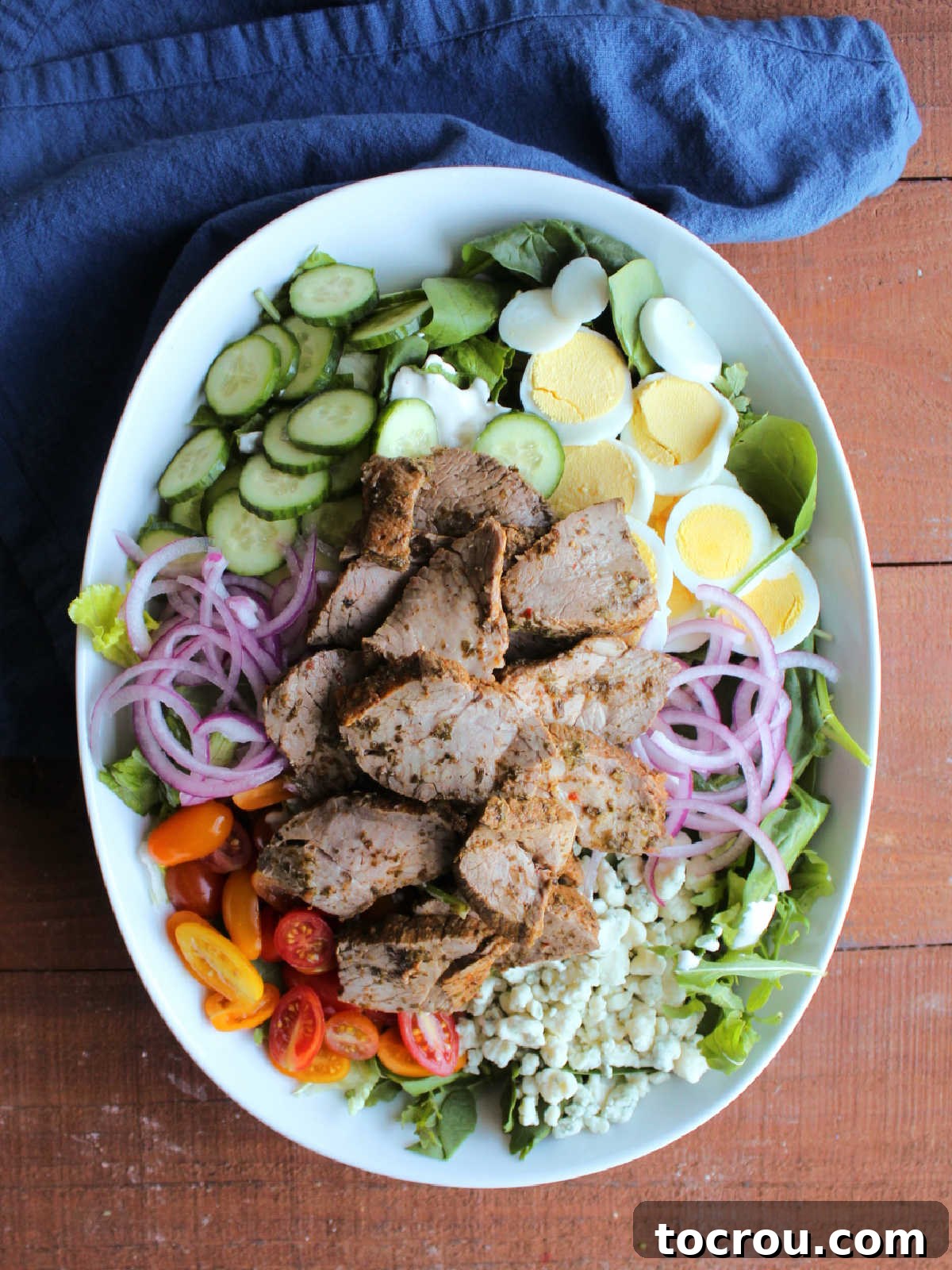 Fiercely Seared Rare Steak Salad 7 Large serving bowl of steak salad with various vegetables, cheese, and eggs arranged around warm steak.