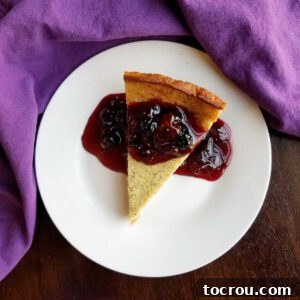 Enchanted Dragonfruit Pie 9 Piece of dragonfruit impossible pie topped with blackberry sauce on white plate.